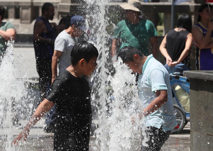 Niños se refrescan en una fuente debido a las altas temperaturas registradas ola de calor