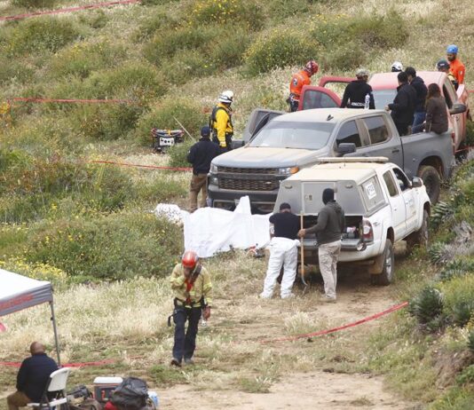 Peritos forenses trabajan en la zona donde se localizaron los cuerpos de dos surfistas australianos