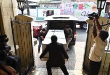 Trabajadores cargan el féretro con el cuerpo del hondureño Maynor Suazo