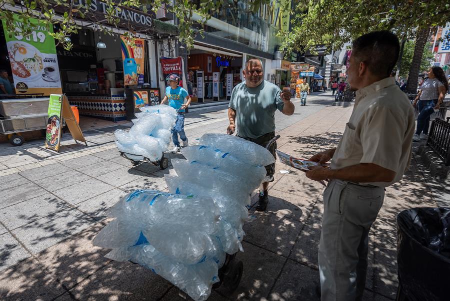 Trabajadores transportan bolsas de hielo este mi&eacute;rcoles, en la ciudad de Monterrey