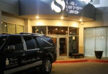 Un coche fúnebre estacionado frente al lugar en dónde son velados Jake y Callum Robinson