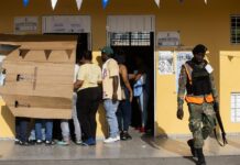 Cierran oficialmente los colegios en comicios presidenciales y legislativos dominicanos Votantes se protegen del sol en un centro de votación luego de una jornada de elecciones este domingo en Santo Domingo