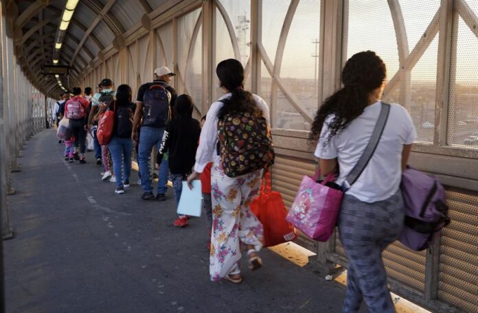 Inmigrantes pasan por el puerto de entrada de la frontera Inmigrantes