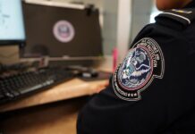 Un agente de la Oficina de Aduanas y Protección Fronteriza de Estados Unidos (CBP) mira desde su ventanilla a los inmigrantes q