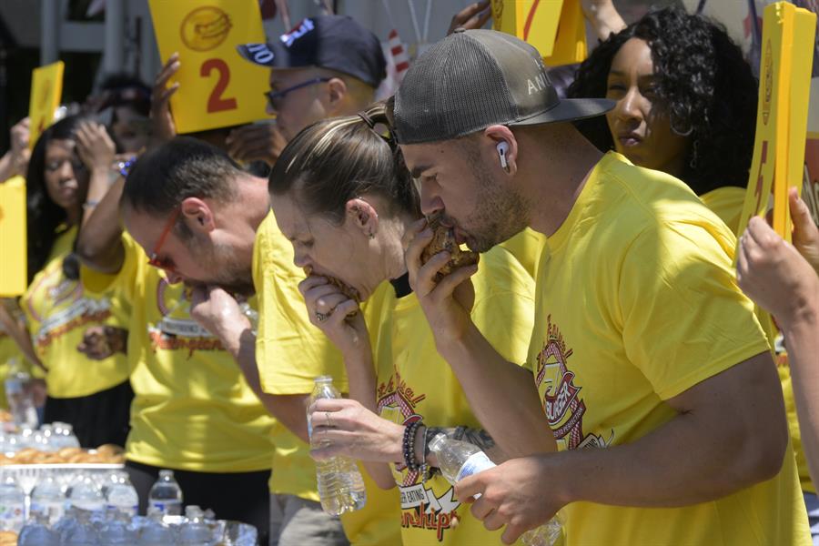 Dan 'Killer' Kennedy (i), Molly Schuyler (c), y Joel Hansen participan de la 15 edici&oacute;n del concurso anual de comer hamburguesas