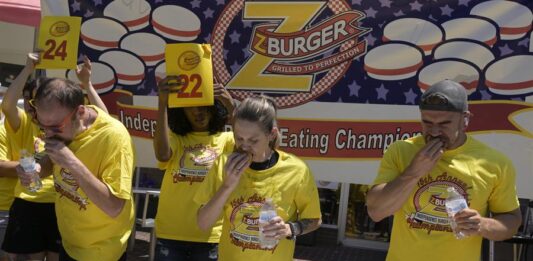 Los concursantes Dan 'Killer' Kennedy (i), Molly Schuyler (c), y Joel Hansen participan de la 15 edición del concurso anual de comer hamburguesas