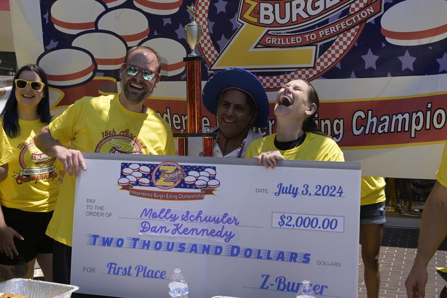 Los concursantes Dan 'Killer' Kennedy y Molly Schuyler sostienen el cheque del primer puesto de la 15 edici&oacute;n del concurso anual de comer hamburguesas