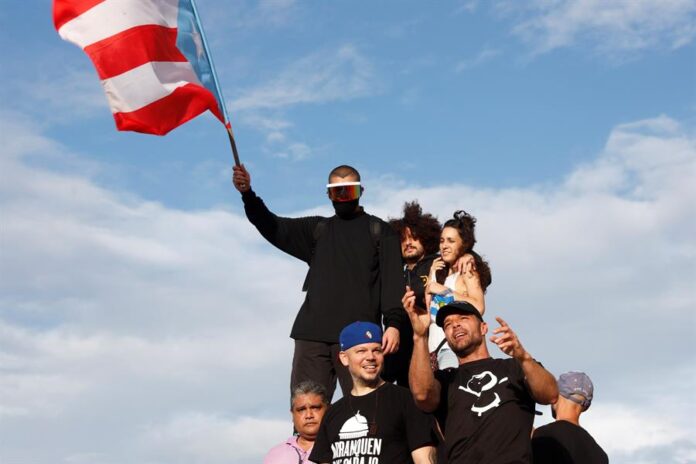 artistas puertorriqueños Bad Bunny (i-arriba), Residente (c-abajo), Dj Sinsuela (c-arriba), Ile (d-arriba) y Ricky Martin (d) durante una manifestación contra el gobernador de Puerto Rico