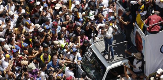 La líder de la oposición venezolana María Corina Machado (d) pronuncia un discurso frente a seguidores