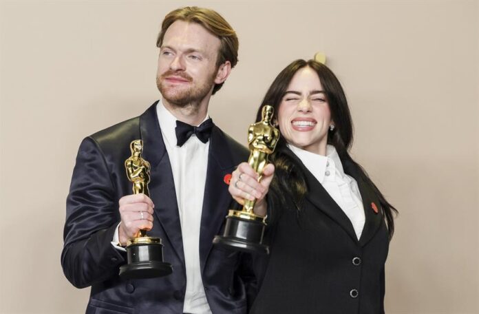Billie Elish y su hermano Finneas O'Connell posando en la galas de los Óscar