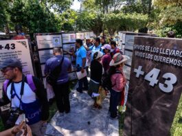 Familiares y amigos de los 43 estudiantes de Ayotzinapa, observan placas en memoria de sus desaparecidos
