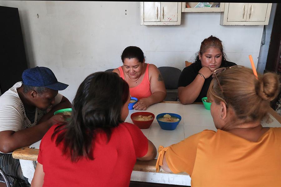 Un grupo de migrantes consumen alimentos en el albergue 'Pan de Vida'