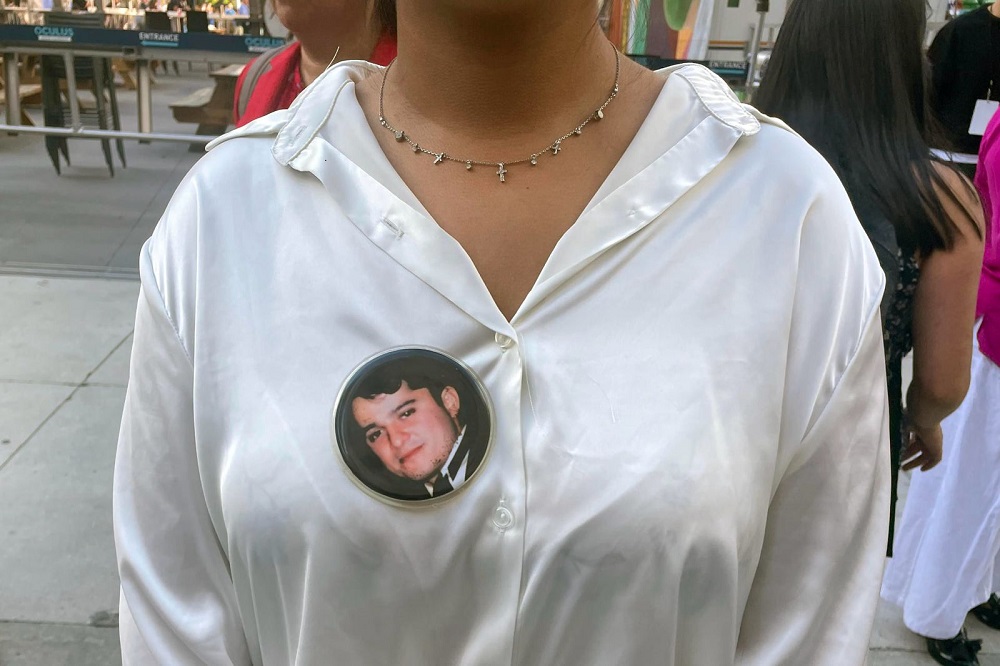 Una mujer usa un pin con la cara de un familiar fallecido en el atentado del 11-S