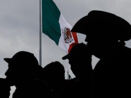 Grupos piden desde EE.UU. a Sheinbaum defender a migrantes y construir un "México más justo" Personas escuchan el discurso de la presidenta de México, Claudia Sheinbaum