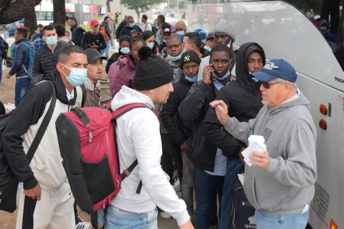 Robert Vivar (d), de la Iglesia Episcopal de San Diego, hablando con un grupo de migrantes Robert Vivar (d), de la Iglesia Episcopal de San Diego, hablando con un grupo de migrantes