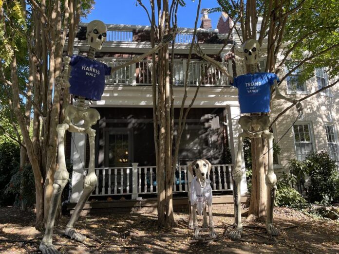 decoración de Halloween con dos esqueletos portando camisetas de la formula electoral Harris-Walz, y de Trump-Vance