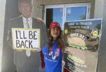 la mexicana Betty Rivas, posando junto a los carteles a favor del expresidente republicano Donald Trump