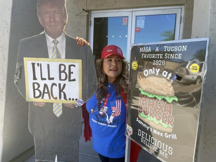 la mexicana Betty Rivas, posando junto a los carteles a favor del expresidente republicano Donald Trump