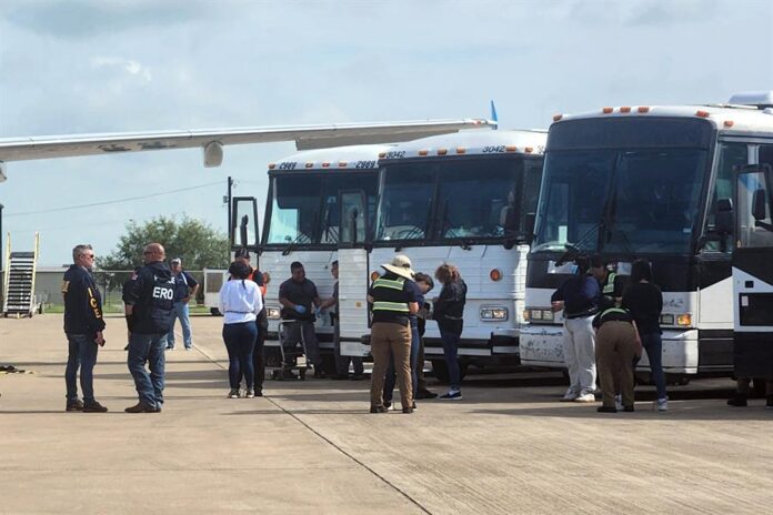 oficiales de migración mientras requisan a unos migrantes antes de ser deportados deportación