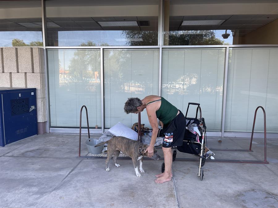 persona sin hogar acariciando a su perro en el pasillo de entrada del Ayuntamiento de Tucson en Arizona