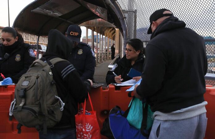 Personas hacen fila para cruzar la frontera hacia Estados Unidos en el Puente Internacional inmigrantes