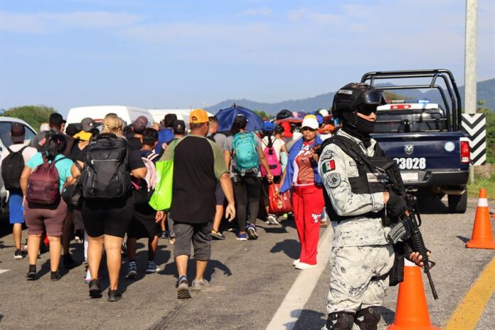 Un integrante de la Guardia Nacional resguarda una caravana de migrantes migrantes