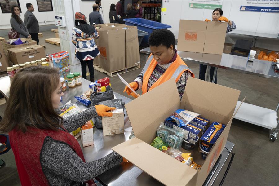 Una persona organiza las cajas y bolsas de los alimentos que se repartir&aacute;n durante el D&iacute;a de Acci&oacute;n de Gracias (2)