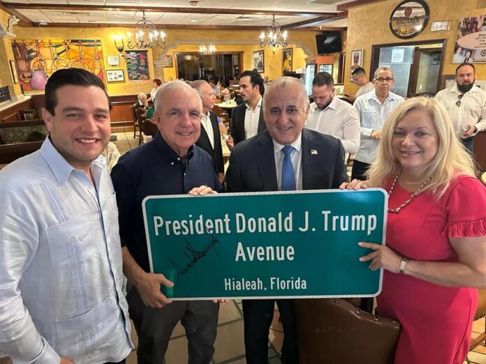 sostienen la placa que designa una avenida con el nombre del presidente electo de Estados Unidos, Donald Trump.
