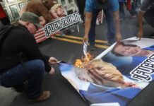 Personas queman carteles con la imagen de Donald Trump durante una manifestación frente a la Embajada de Estados Unidos