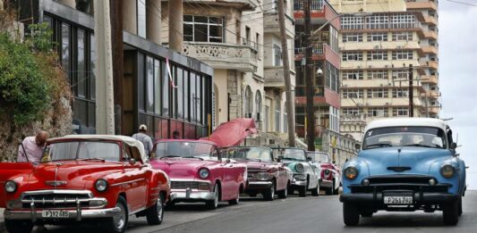 autos clásicos de la década de los 50 y de fabricación en los Estados Unidos sobre una avenida, en La Habana