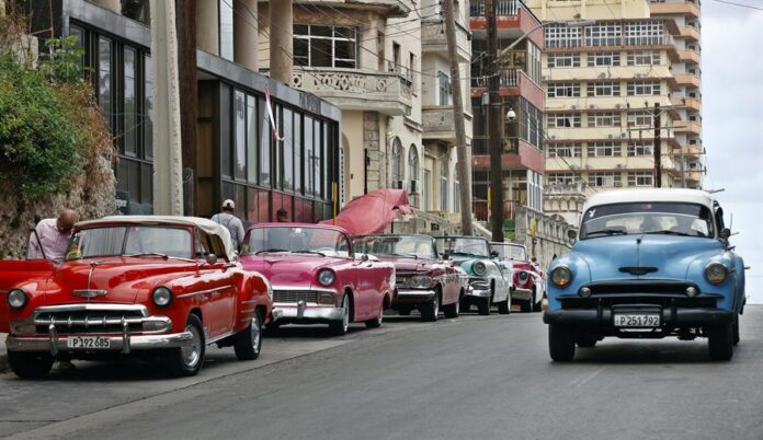 autos clásicos de la década de los 50 y de fabricación en los Estados Unidos sobre una avenida, en La Habana autos clásicos de la década de los 50 y de fabricación en los Estados Unidos sobre una avenida, en La Habana