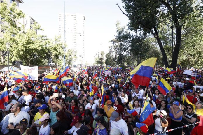 - Ciudadanos venezolanos asisten a una manifestación este jueves, en Santiago
