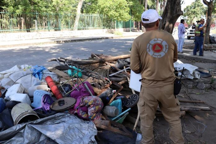 Integrantes de equipos de protección civil, retiran este jueves un campamento de migrantes en la ciudad de Tapachula inmigrantes