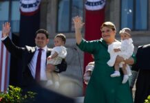 La gobernadora de Puerto Rico Jenniffer Gonzalez (d) saluda acompañada por su cónyuge