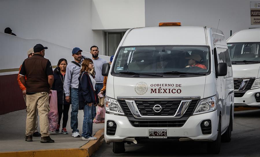 Migrantes deportados suben a camionetas para ser trasladados a albergues en el puerto fronterizo de El Chaparral