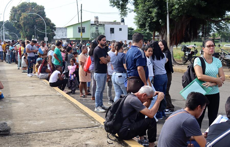 Migrantes hacen fila en una estaci&oacute;n migratoria este viernes, en el municipio de Tapachul,