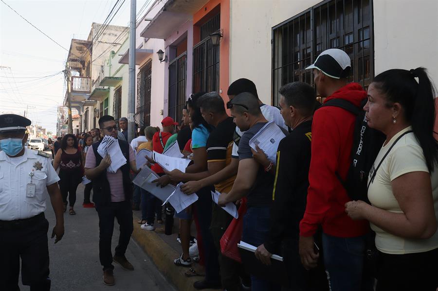 Migrantes hacen fila para realizar sus procesos migratorios este viernes (1)