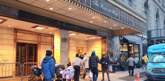 Padres esperan con sus niños al autobús escolar este lunes en Nueva York