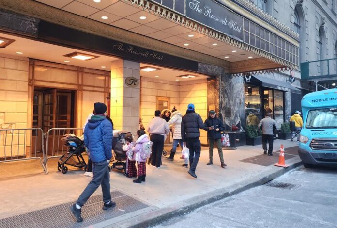 Padres esperan con sus niños al autobús escolar este lunes en Nueva York