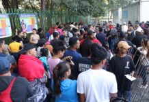 Personas hacen fila para realiza tramites migratorios