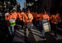 Personas participan en un desfile como parte de la convocatoria del oficialismo
