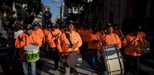 Personas participan en un desfile como parte de la convocatoria del oficialismo