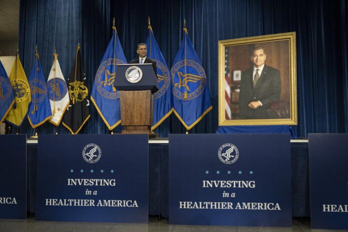 Xavier Becerra, hablando junto a su retrato oficial
