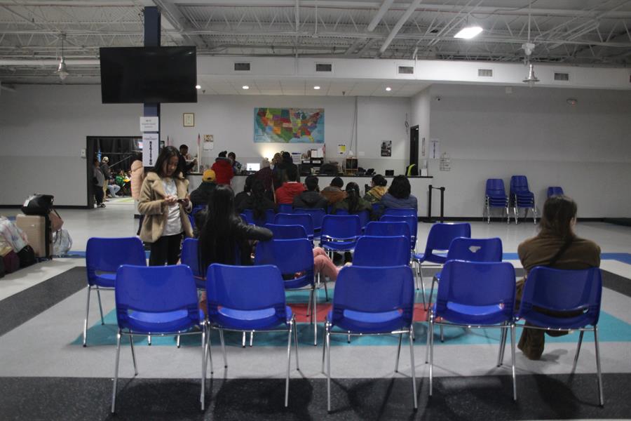 migrantes esperan su turno para registrarse y entrar al albergue Caridades Católicas en McAllen, Texas
