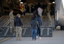 Trump se queja de que los tribunales no quieren permitirle sacar a los criminales del país un grupo de indocumentados sentados dentro de un avión militar camino a su deportación.