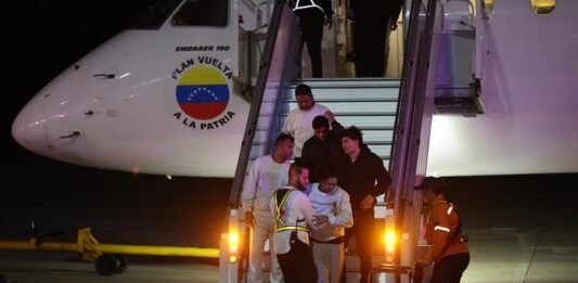 Ciudadanos venezolanos descienden de un avión tras ser deportados desde Estados Unidos,