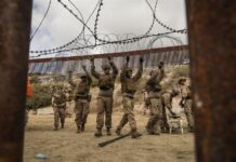 Integrantes del ejercito de Estados Unidos refuerzan un muro con alambre de púas este jueves, en la frontera con la ciudad de Tijuana, (2)