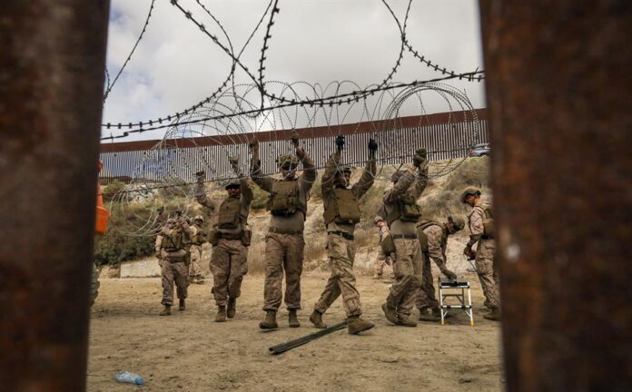 Integrantes del ejercito de Estados Unidos refuerzan un muro con alambre de púas este jueves, en la frontera con la ciudad de Tijuana, (2) Integrantes del ejercito de Estados Unidos refuerzan un muro con alambre de púas este jueves, en la frontera con la ciudad de Tijuana, (2)