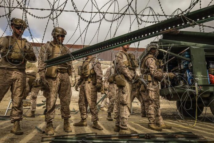 Integrantes del ejercito de Estados Unidos refuerzan un muro con alambre de púas este jueves, en la frontera con la ciudad de Tijuana, (3)