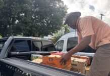 Leonard Phophil carga a un vehículo alimentos que le donan para entregar a los inmigrantes este lunes, en San Juan